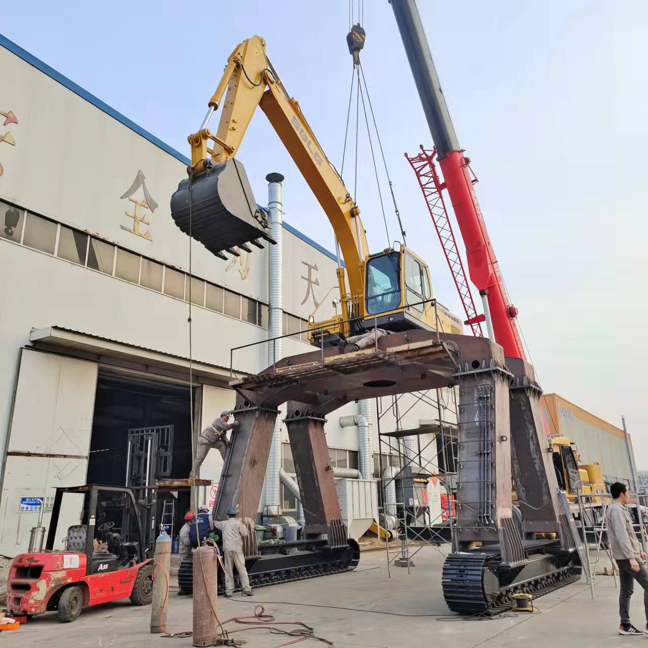 What is the difference between a reach stacker and an excavator straddle carrier?